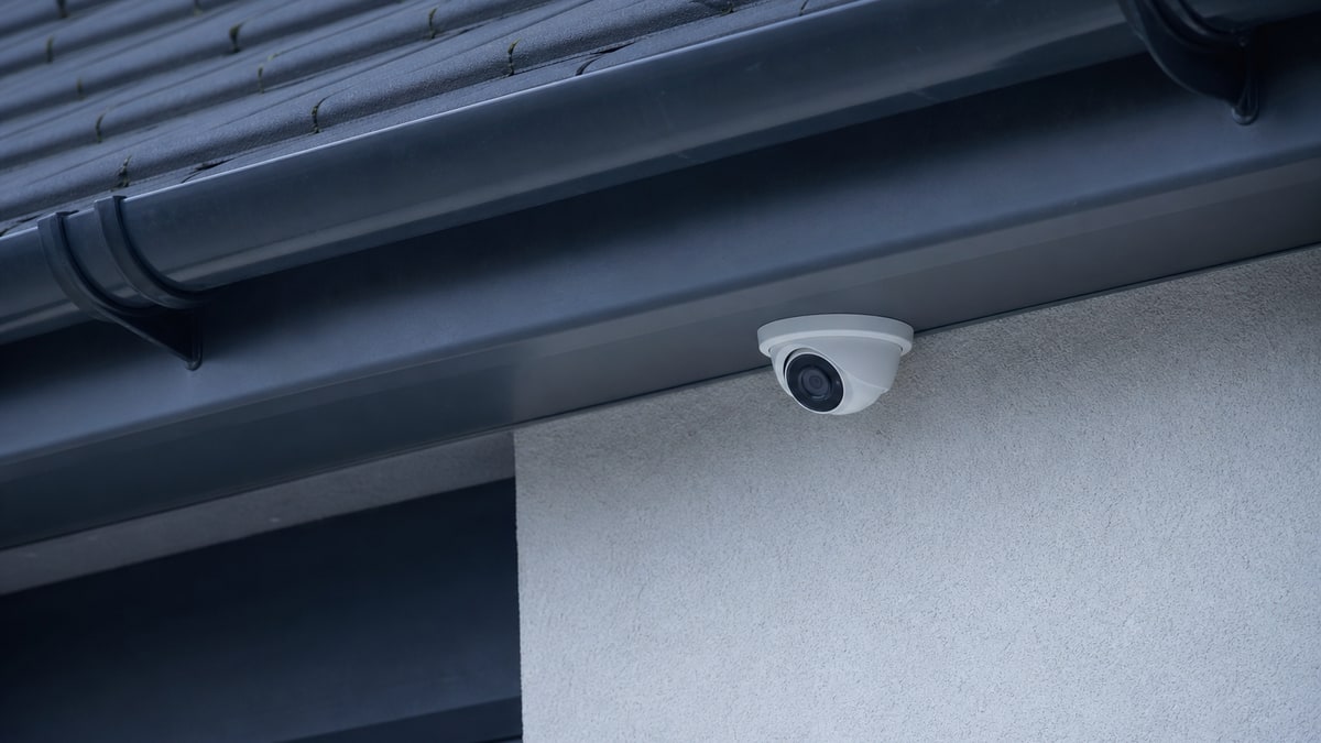 Discreet CCTV camera mounted on a white exterior wall