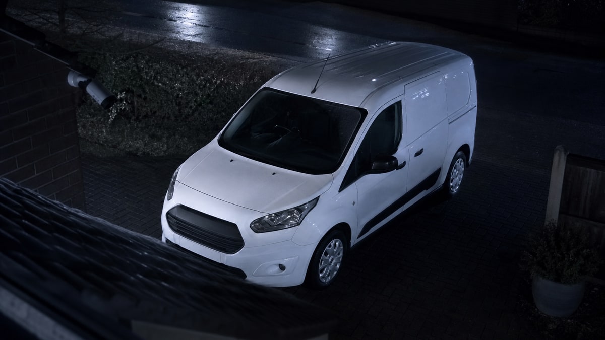 White trade van parked on a residential street at dusk